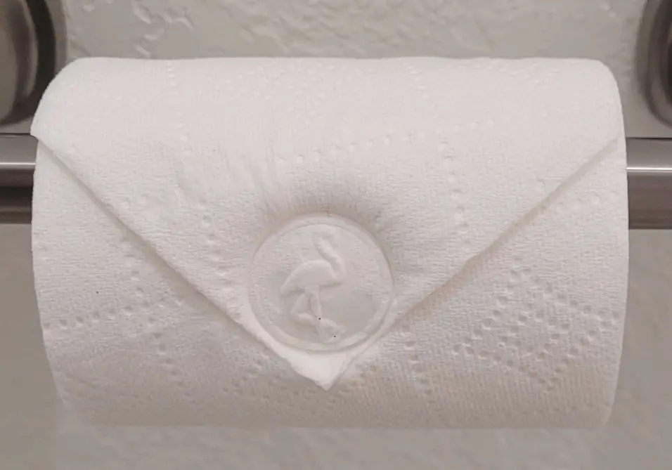 A toilet paper roll folded into a point, the Green Flamingo mark embossed in the fold